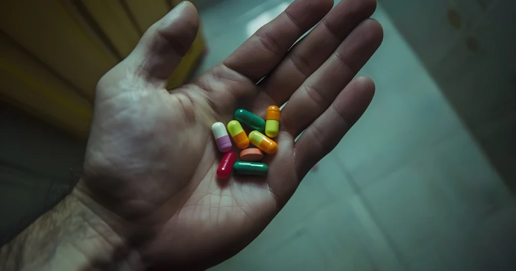 Hand with pills dark environment